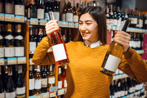 A smiling girl with two bottles of wine in wine store-Bottle Barn