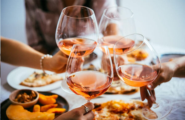 4 persons cheering with wine with some Indian food on the table-Bottle Barn