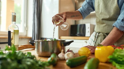 A man is using white wine for cooking-Bottle Barn